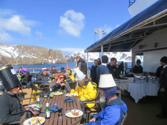 Almoço festivo de chapéus criativos no deck do Sea Spirit, na baía de Deception Island, na Antártida (foto de France Dione)